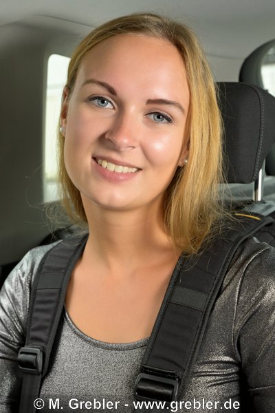 Junge Frau im Auto festgeschnallt mit einem Gurtsystem für Personen mit besonderen Bedürfnissen 