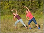 Zwei junge Frauen beim Stretchen nach dem Laufen 