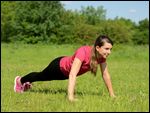 Frau macht Liegestützen in Wiese