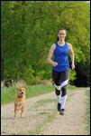 Junge Frau beim Joggen mit ihrem Hund (Mischling) 