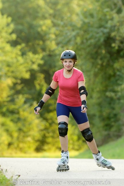 Frau mit Helm und Schoner beim Rollerblading