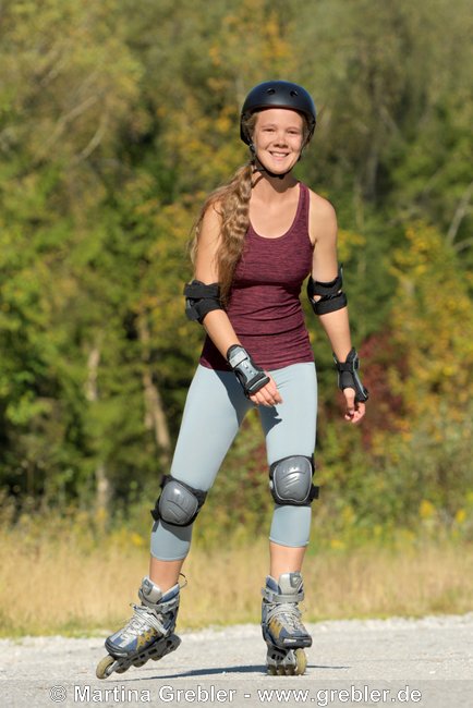 Frau mit Helm und Schoner beim Rollerblading