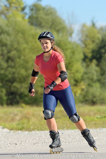 Frau mit Helm und Schoner beim Rollerblading