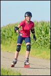 Jugendliche beim Rollerskate fahren mit Helm und Schoner 