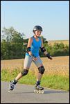 Frau mit Helm und Schoner beim Rollerblading