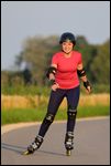 Frau mit Helm und Schoner beim Rollerblading