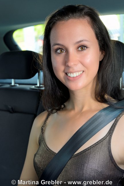 Junge Frau angeschnallt auf dem Rücksitz im Auto 